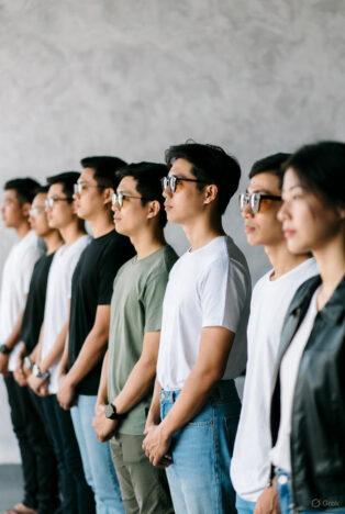 A diverse group of young Asian students standing in a line, looking upward with determination, representing SSC exam aspirants.