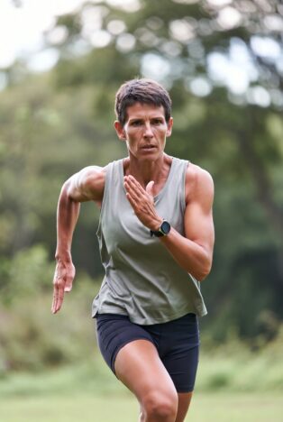 35-year-old fit woman running strongly in park